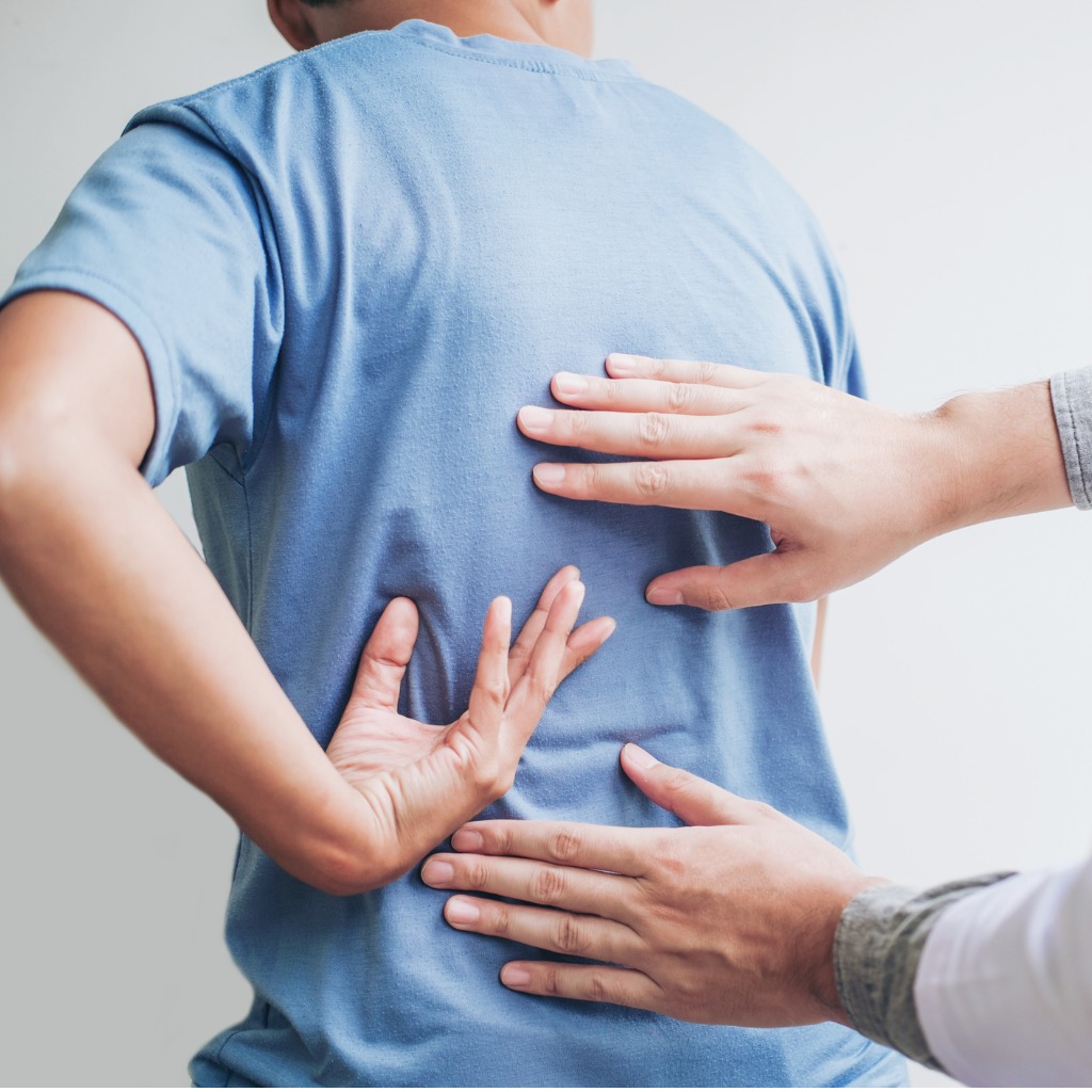 doctor-consulting-with-patient-back-problems-physical-therapy-concept-picture-id1007757616